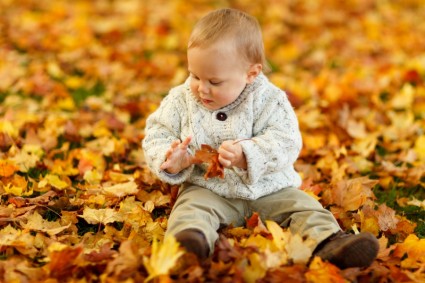 chłopiec siedzi w parku w jesieni