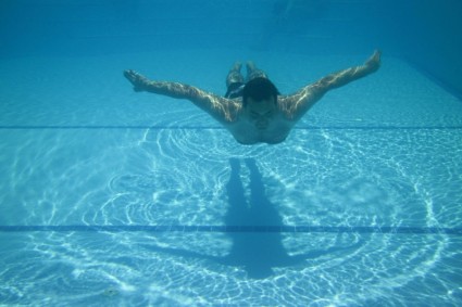 homme nageant dans la piscine