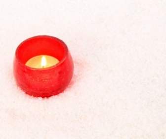 雪の中で赤い蝋燭