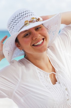 người phụ nữ với một chiếc mũ trên bãi biển